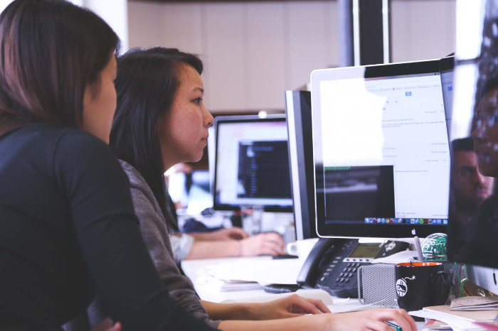 Image of a woman training a young employee at an office