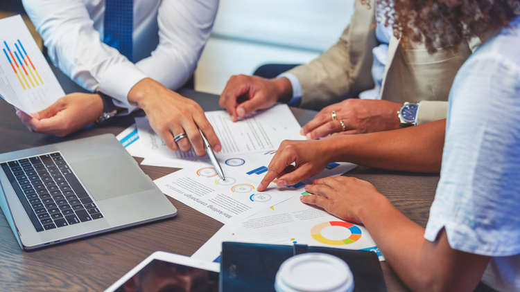 Image showing a group of office workers checking financial documents on a desk