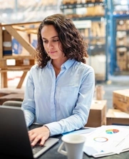 Woman working in factory with laptop concentrated