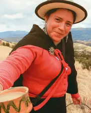 Image of an Ecuadorian farmer woman offering a cup of fresh milk