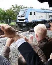 train and passengers waving 