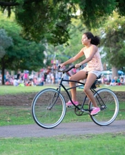 Image of a girl riding her bike on a park during summer