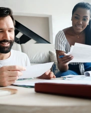 La imagen muestra dos emprendedores, un hombre y una mujer, revisando papeles de una pequeña empresa en Panamá