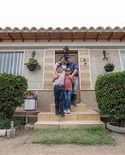 Image of a happy family in front of their new house.