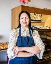 Image of an smiling woman at her bakery
