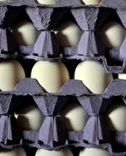 La imagen muestra varios maples de huevos apilados