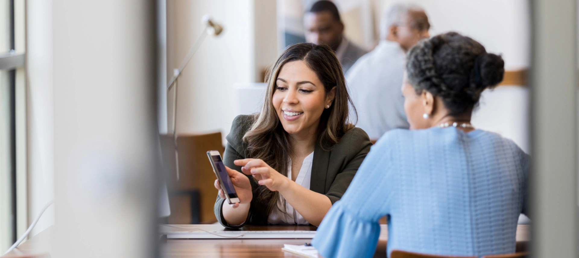Banking professional showing customer how to use banking mobile app