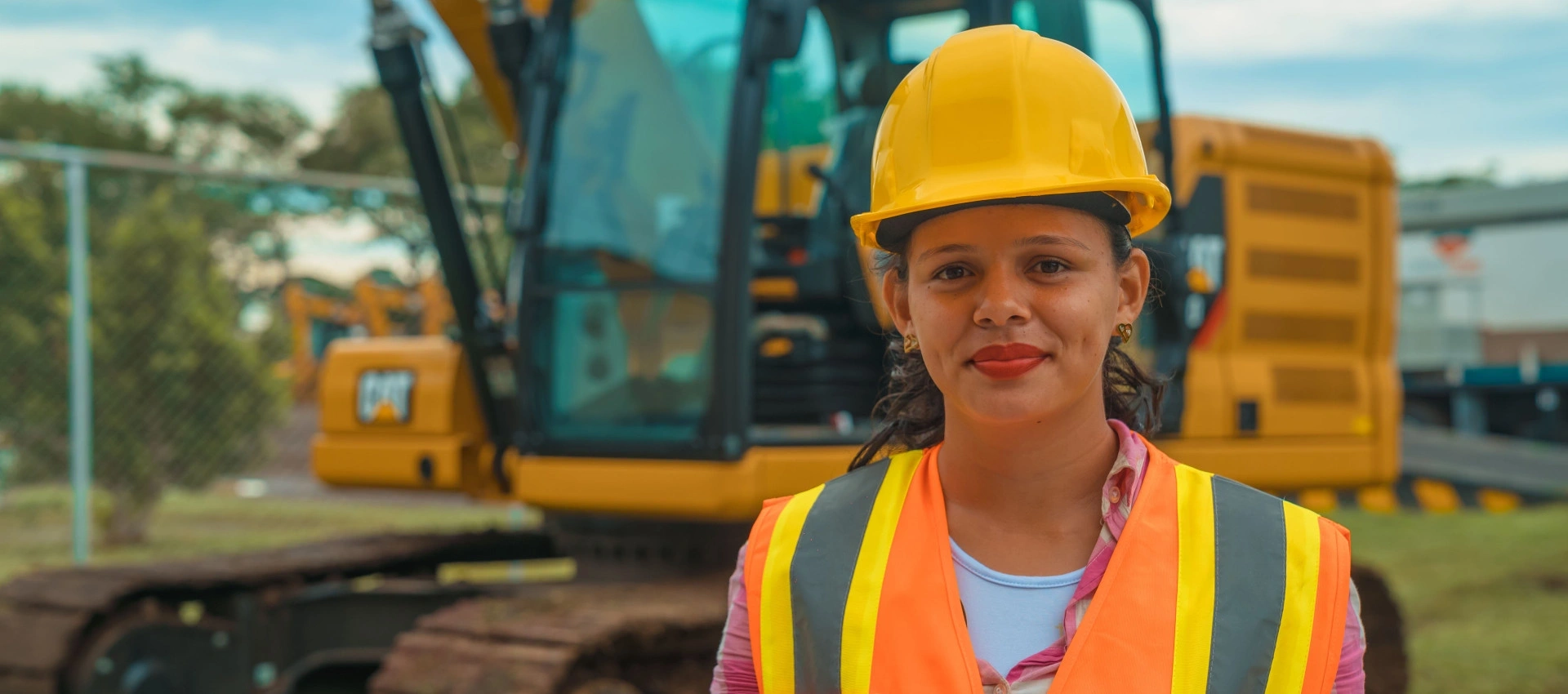 Image of a female construction worker wearing a yellow helmet.