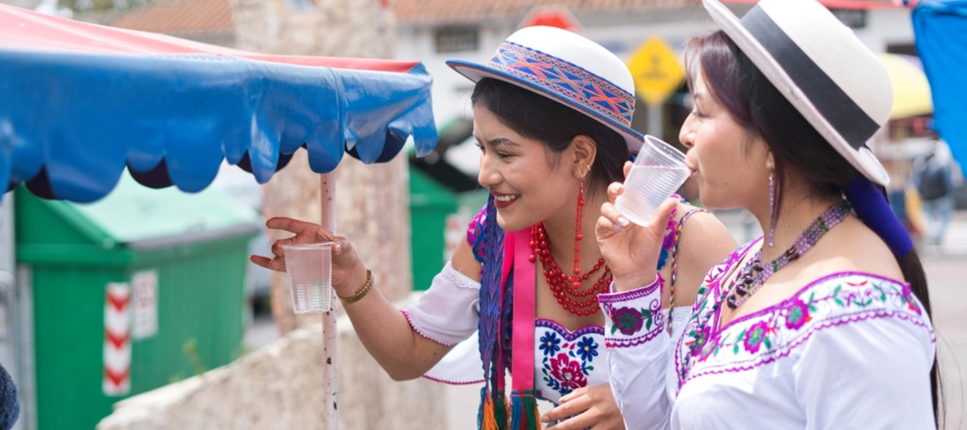 Banner image of two indigenous Latin American women enjoying a fair
