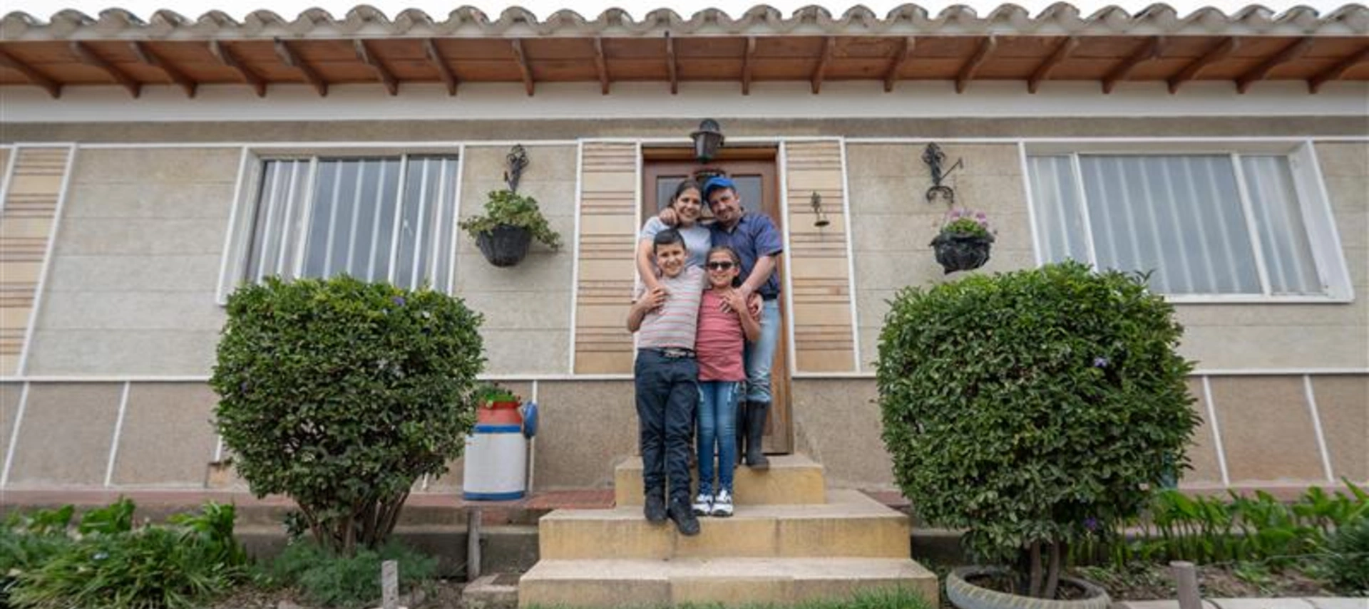 Image of a happy family in front of their new house.
