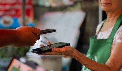 Una mujer recibiendo un pago electrónico con su celular