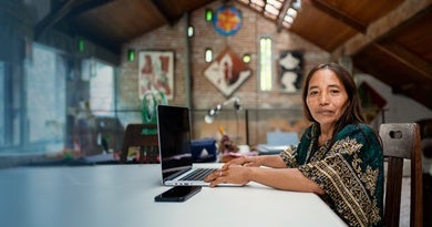 Uma mulher indígena trabalhando em seu laptop