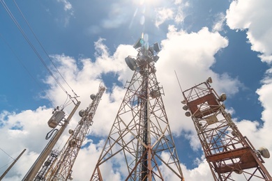 Multiple telecommunications towers equipped with antennas and transmission equipment, symbolizing broadband and digital infrastructure.