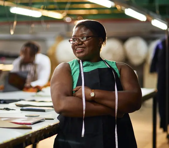 Imagen de una mujer caribeña de pie en un taller de costura.