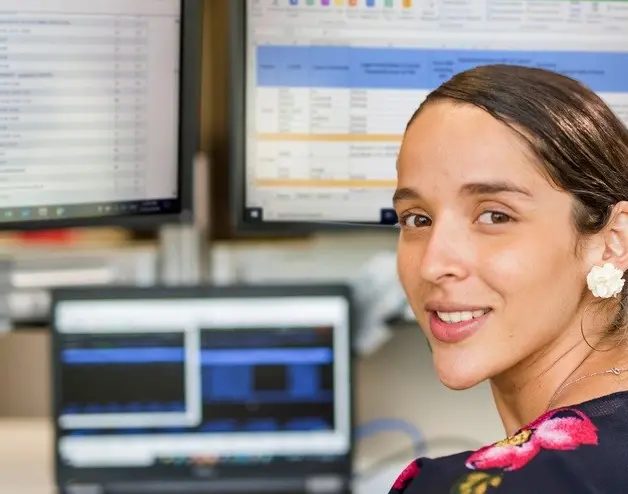 Una mujer sentada frente a monitores de computadora
