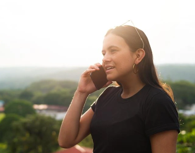 Mujer habla por celular en una zona aislada de costa rica