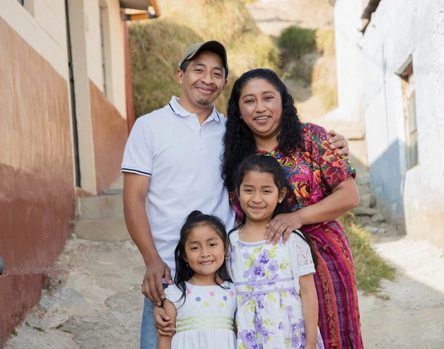 A joyful family moment: a smiling couple with their two daughters, radiating warmth and togetherness.