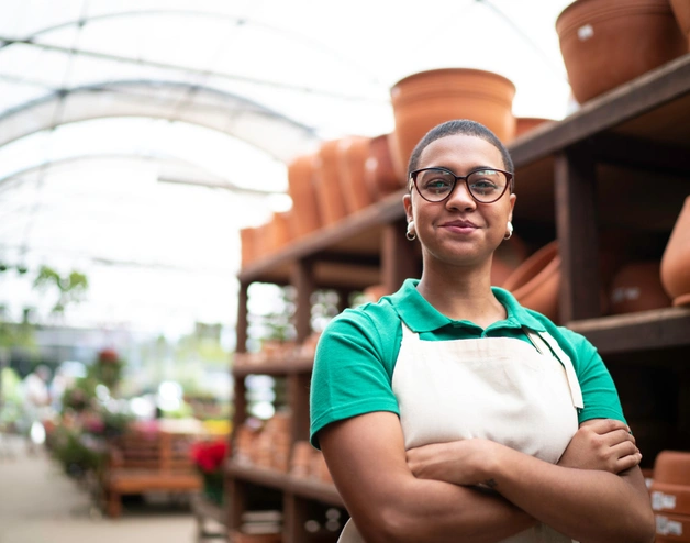 Image of a female Brazilian entrepreneur smiling at her pottery business