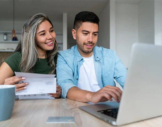 Happy couple paying bills online