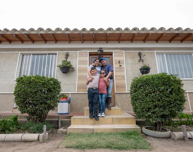 Image of a happy family in front of their new house.