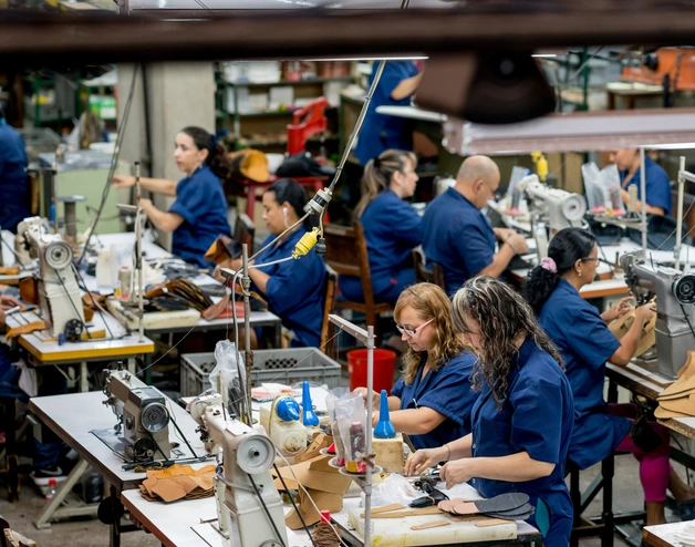 A group of factory workers assembled around a production line