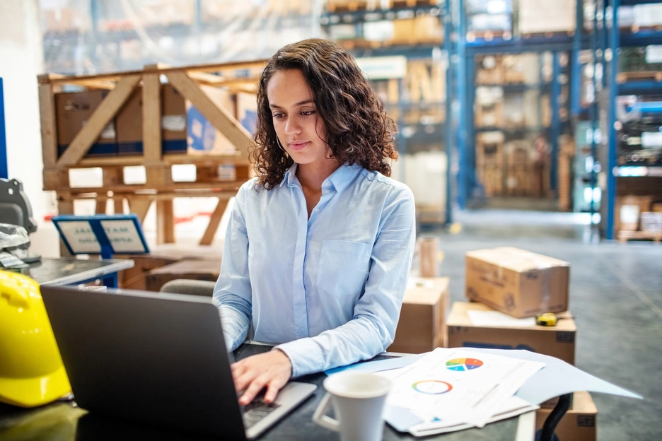 Woman working in factory with laptop concentrated