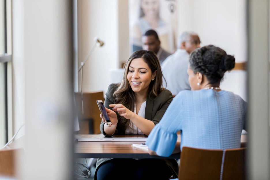 Banking professional showing customer how to use banking mobile app