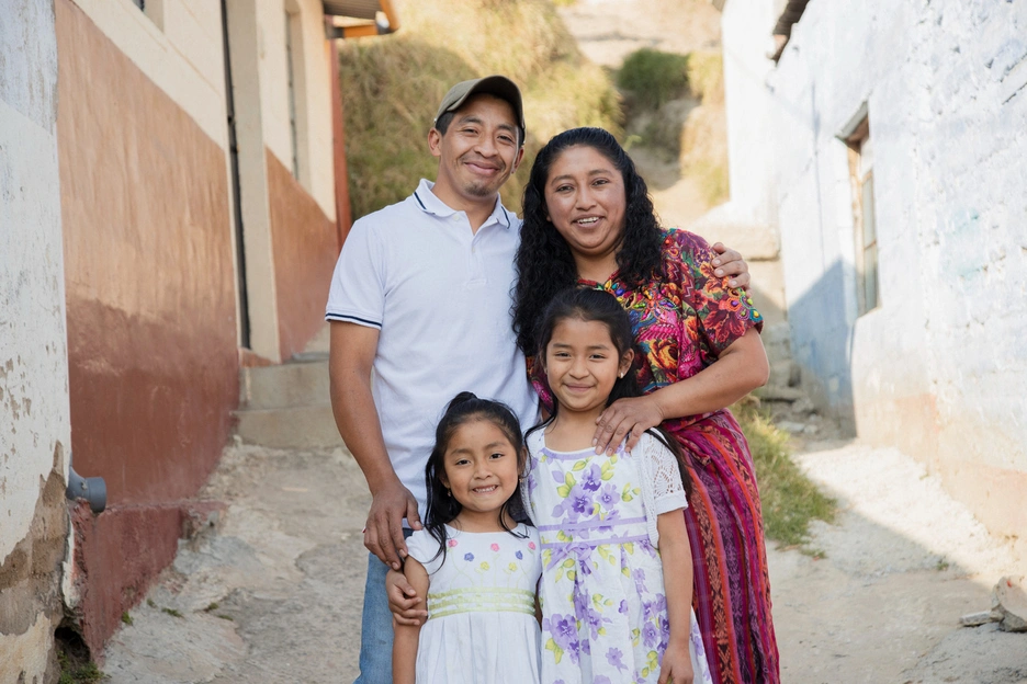 A joyful family moment: a smiling couple with their two daughters, radiating warmth and togetherness.