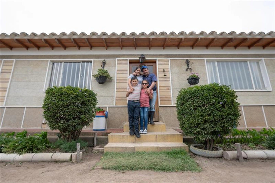 Image of a happy family in front of their new house.