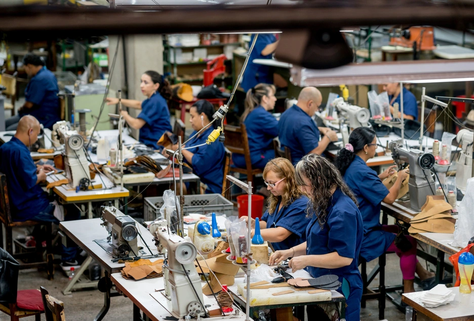 A group of factory workers assembled around a production line